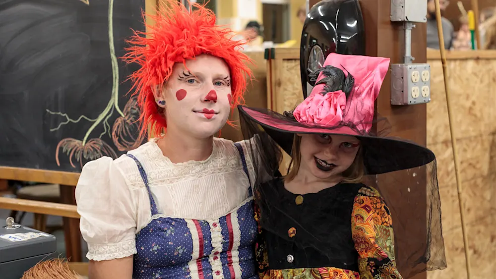 Two kids in clown and witch costumes at Track-or-Treat