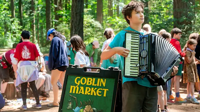 Goblin Market sign with an accordion player and kids trading treasures