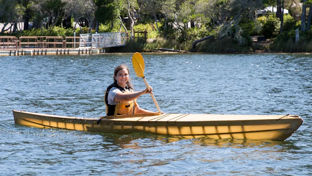 Camper paddling a kayak on the water